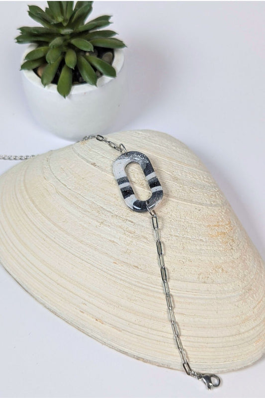 Bracelet en résine noir et blanc au motif graphique, monté sur chaîne argentée, fait main à Montréal