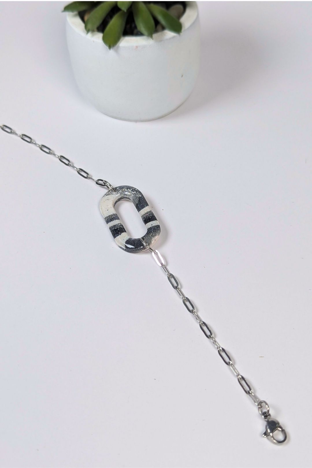 Bracelet en résine noir et blanc au motif graphique, monté sur chaîne argentée, fait main à Montréal
