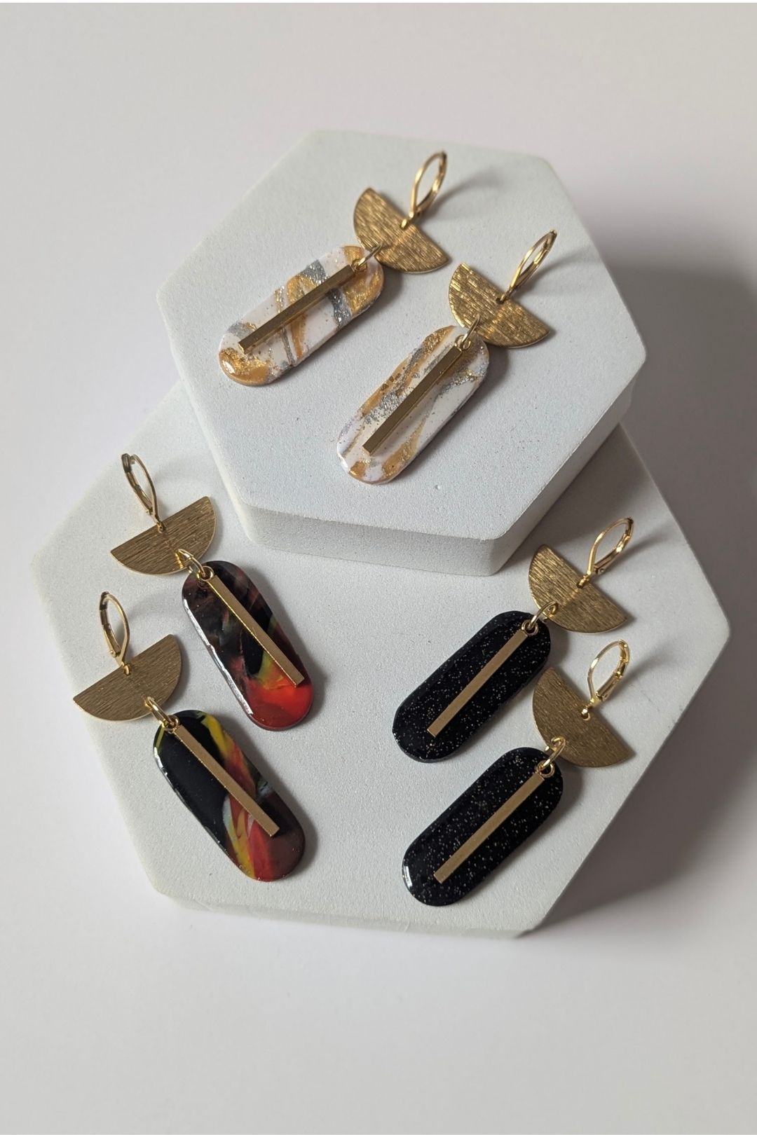 Boucles d’oreilles graphiques en résine marbrée et métal doré, bijou élégant fait à la main.