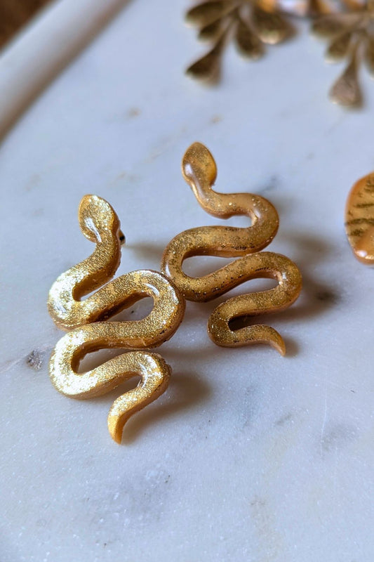Boucles d’oreilles ondulantes motif serpent doré faites à la main, bijou artistique et audacieux.